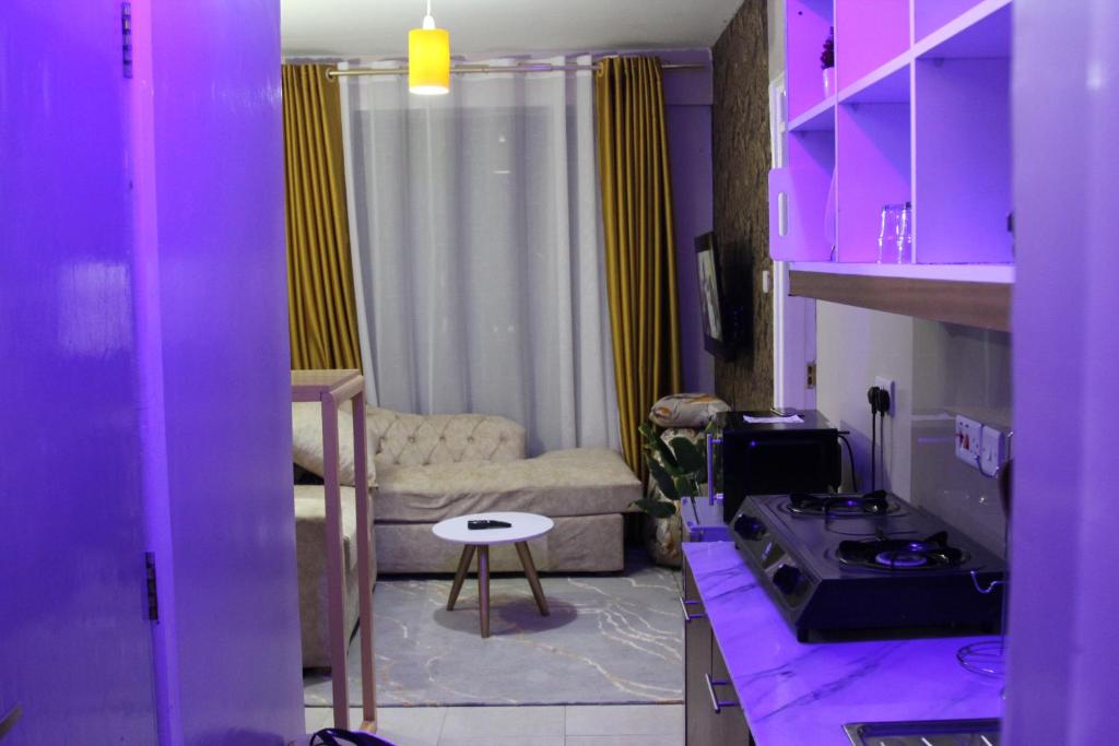 a kitchen with purple cabinets and a living room at Artsy Urban 1Br along Kiambu Road with a pool and scenic views in Kiambu