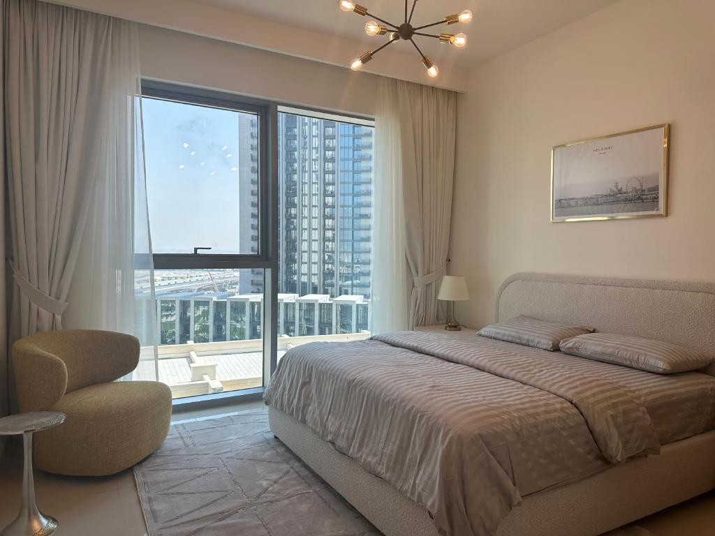 a bedroom with a bed and a large window at ROYAL APARTMENTS DUBAI in Dubai