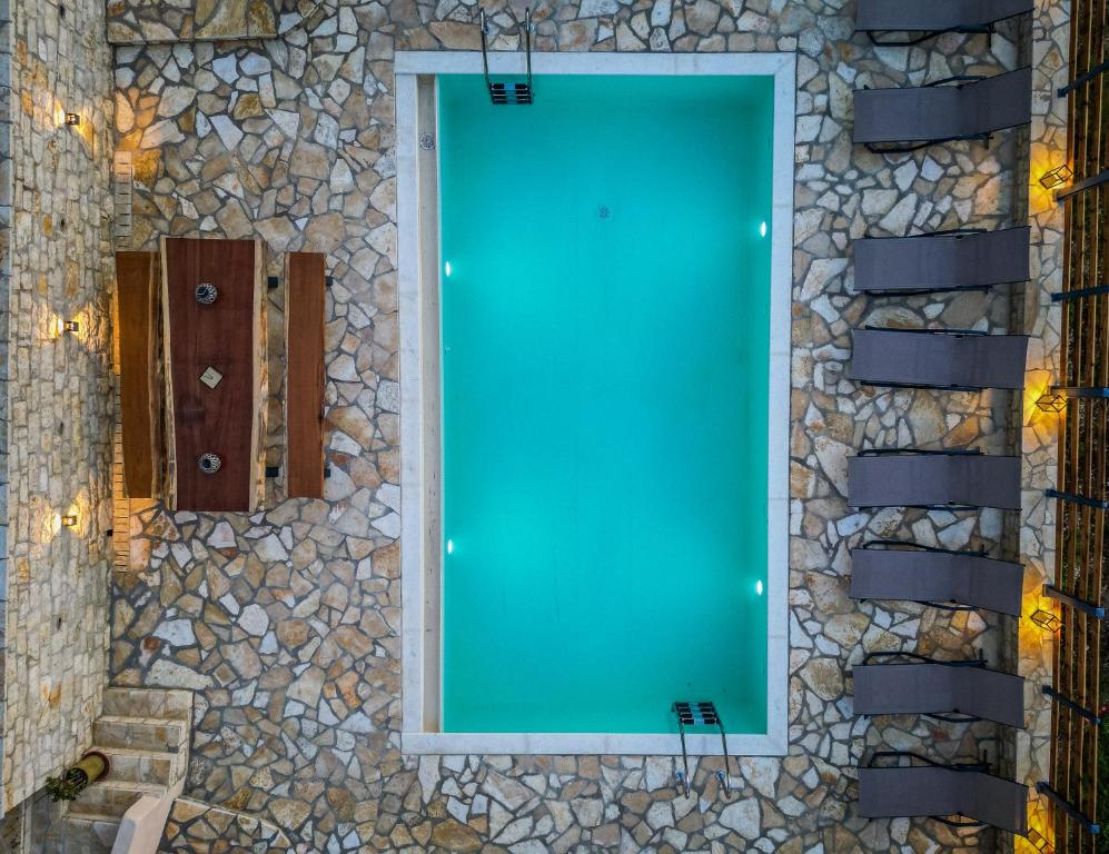 uno specchio sul lato di un muro di pietra di Villa Kostas-NE Corfu with heated salt swimming pool a Agios Spyridon Corfu