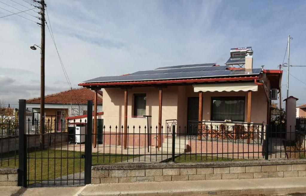 ein Haus mit einem schwarzen Zaun davor in der Unterkunft BYT Village House in Áyios Khristóforos