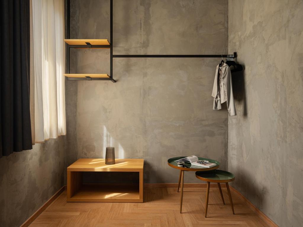 a room with a table and a chair and a table and a shelf at Re Versiliana Hotel in Marina di Pietrasanta