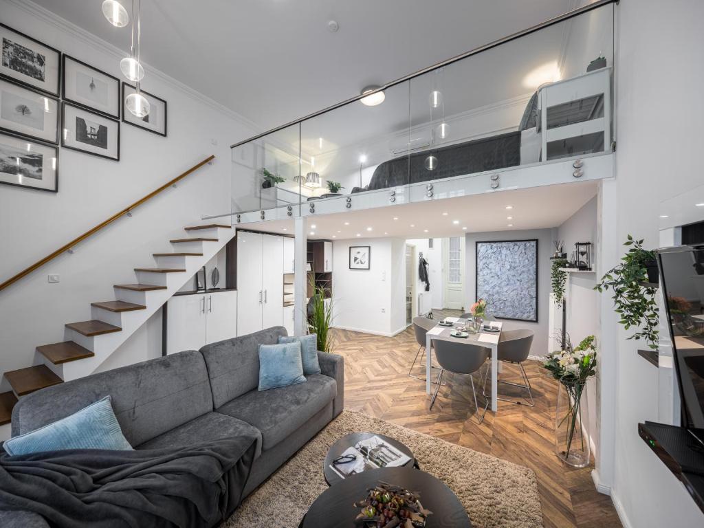 a living room with a couch and a staircase at Riverside Suite in Budapest