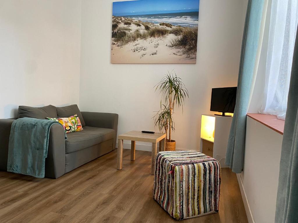 een woonkamer met een bank en een tafel bij Narbonne : Logement idéalement situé in Narbonne