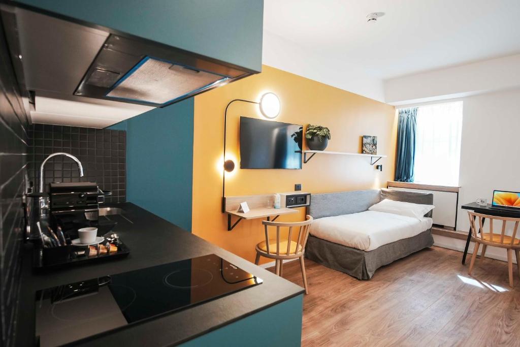 a kitchen and a living room with a bed and a couch at Aparthotel Colombo Roma in Rome