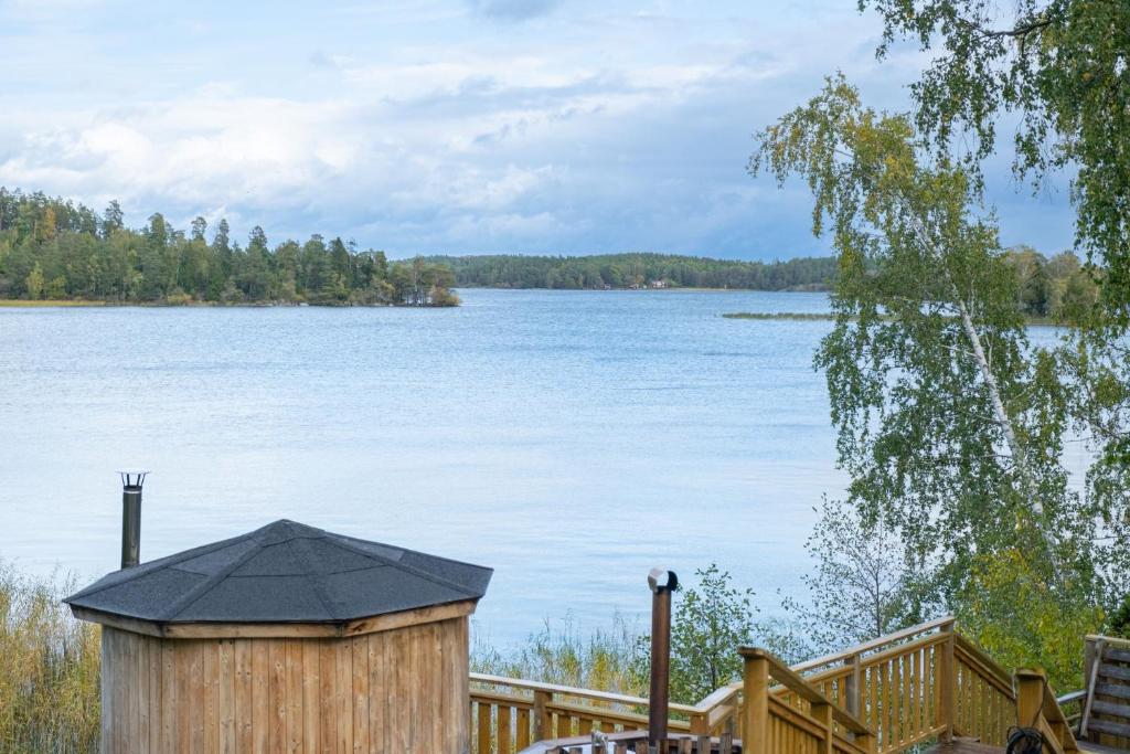 a view of a large lake with a wooden fence at Unique cottage with a view of Malaren, Mariefred in Mariefred