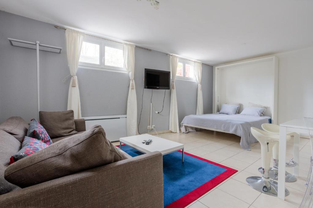sala de estar con sofá y cama en Residence Mont-Blanc Apartment, en Ginebra