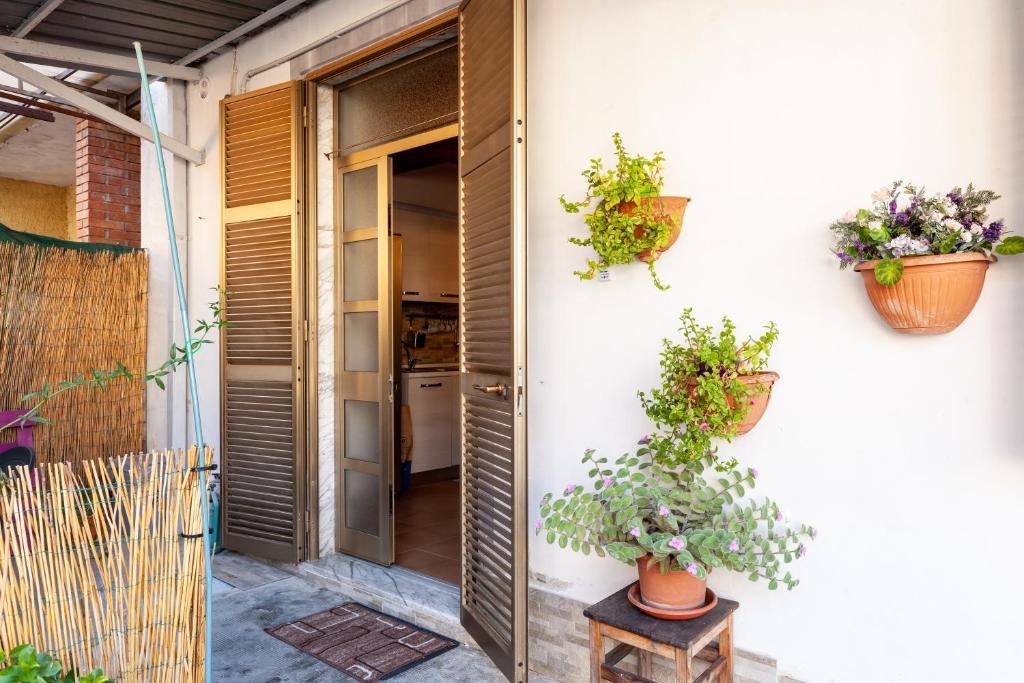 une chambre avec deux plantes en pot sur le côté d'une maison dans l'établissement Il borgo al mare, à Massa