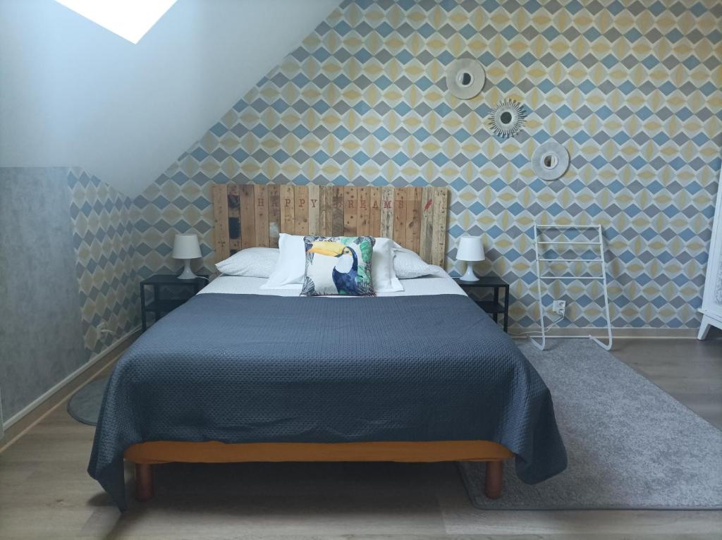 a bedroom with a large bed with a blue blanket at Gîte 4 pers, Jacuzzi privatif & Piscine & Lit cabane in Saint-Georges-sur-Cher