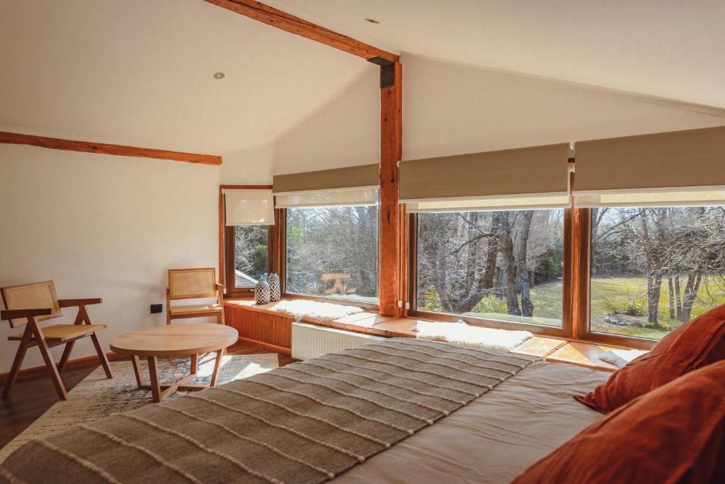 1 dormitorio con cama grande y ventana grande en PURA Hotel, en Coyhaique