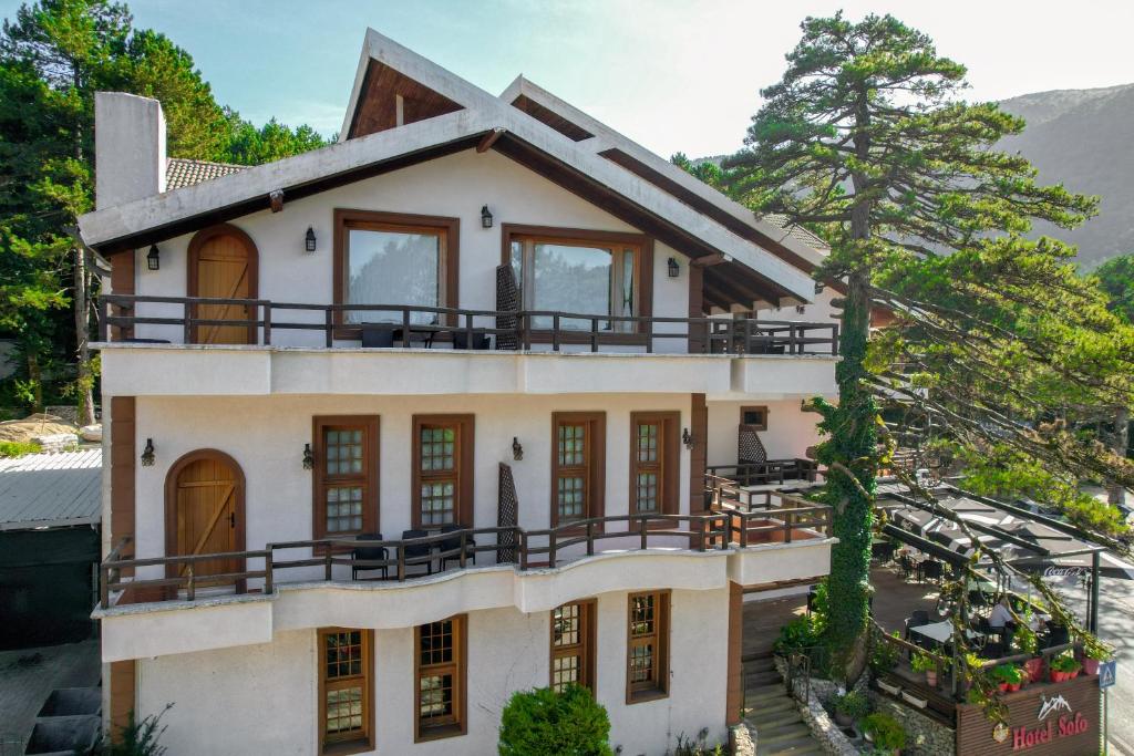 une maison avec un balcon au-dessus dans l'établissement Hotel Sofo, à Llogara