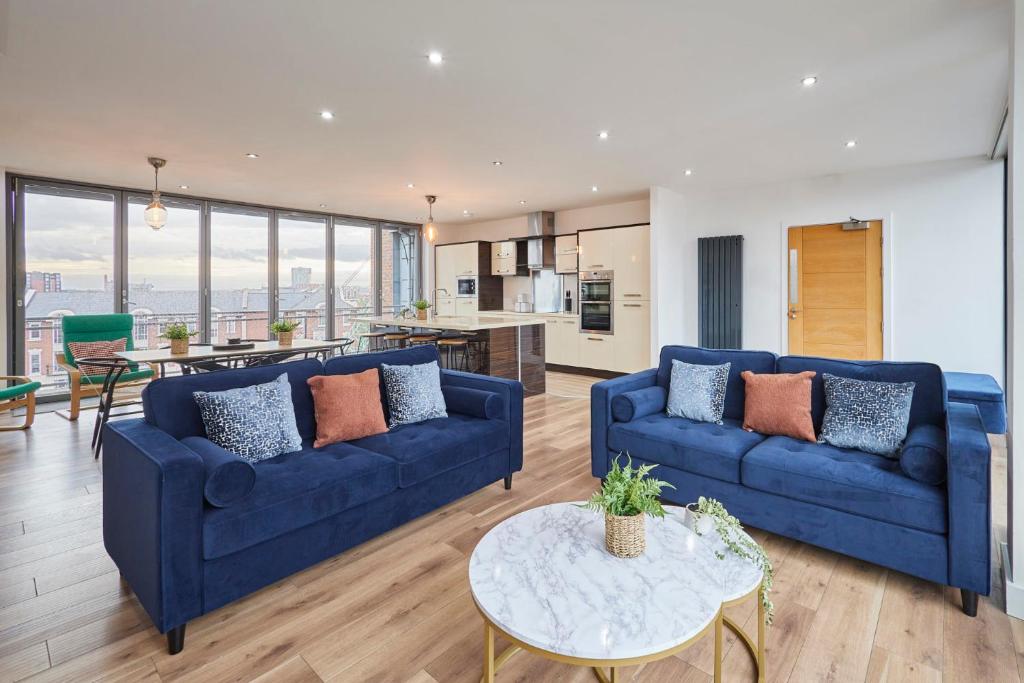 a living room with two blue couches and a table at Host & Stay - The Knight Street Penthouses in Liverpool