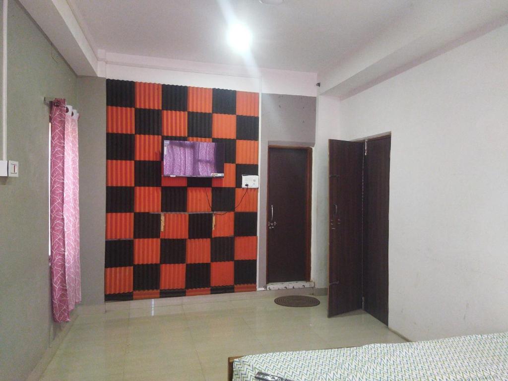 una habitación con una pared con una pared de tablero de ajedrez en OYO HOTEL RASU, en Imphal