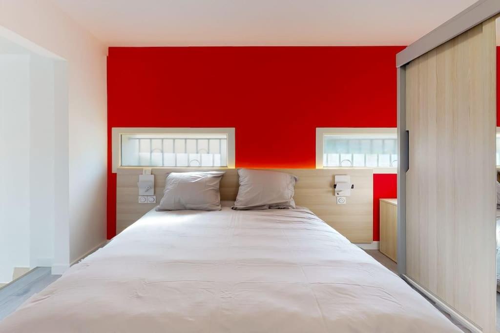 - un grand lit dans une chambre dotée d'un mur rouge dans l'établissement 04.Studio#Creteil#Loft#Cinéma, à Créteil