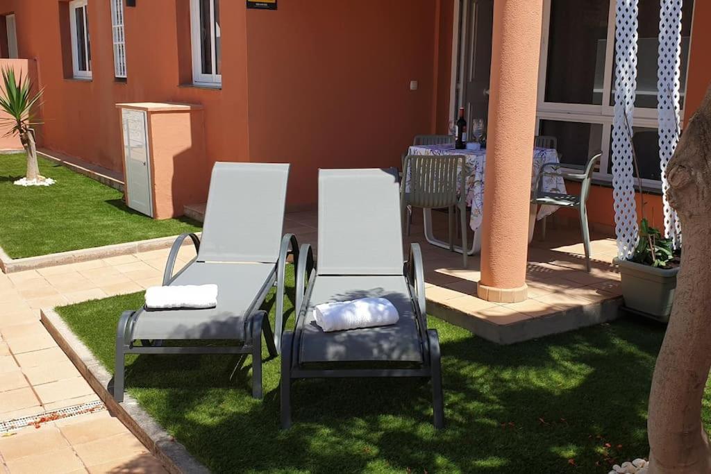 two chairs and a table in a yard at West Corner Caleta de Fuste in Caleta De Fuste