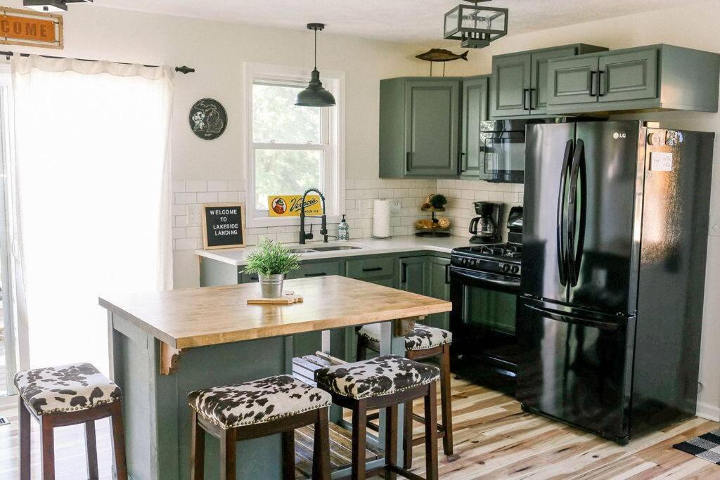 een keuken met groene kasten en een roestvrijstalen koelkast bij Spectacular Lake Views! 