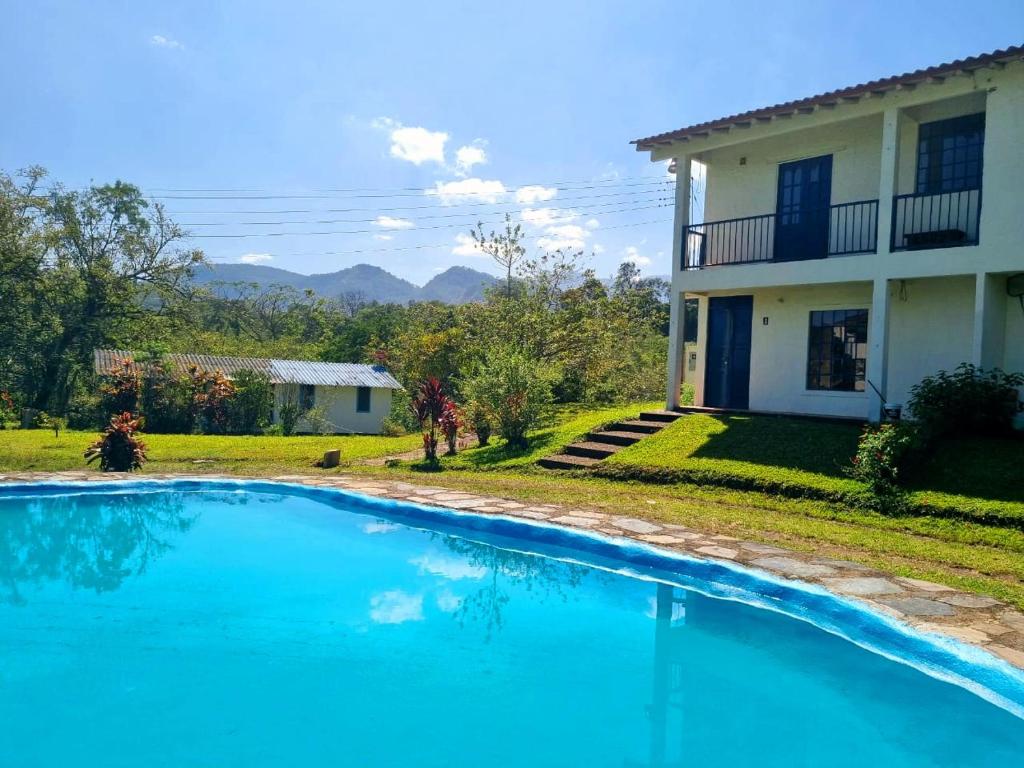 a swimming pool in front of a house at Mountain view house in Sasaima