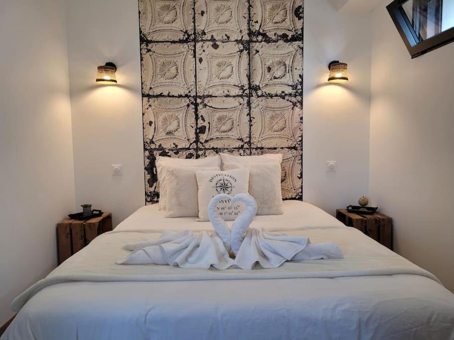 a bedroom with a bed with a heart shaped towel on it at L'Escapade T1 de 30 m2 neuf. in Granville