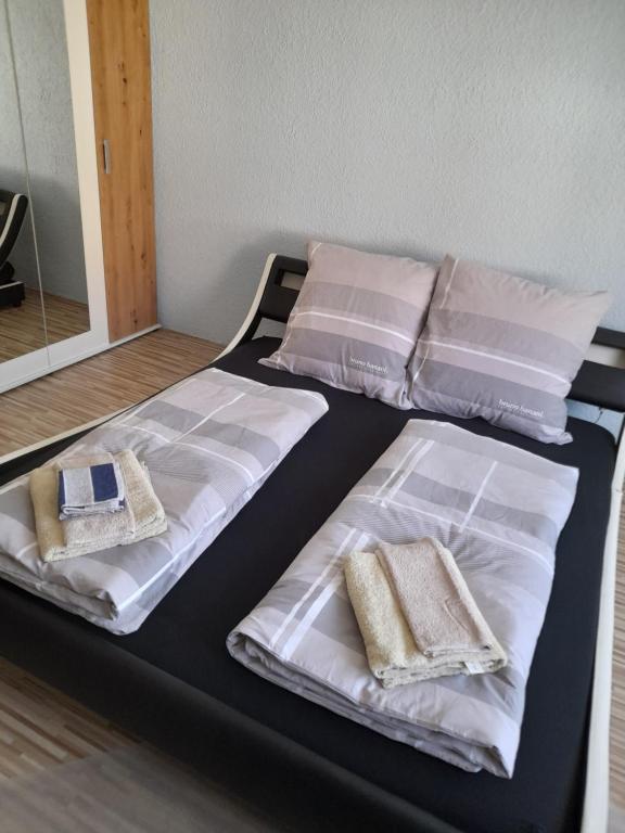 un letto con lenzuola e cuscini bianchi di Casa Jaime a Karlsruhe