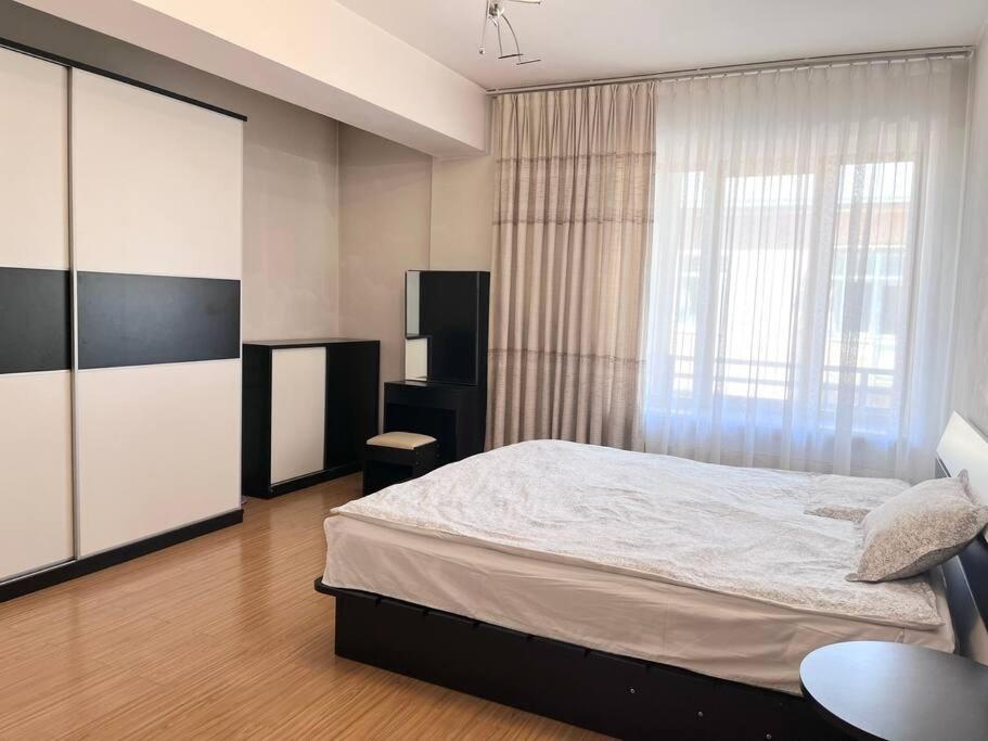 a bedroom with a large bed and a window at LuxHouse-1, near State department store (central location) in Ulaanbaatar
