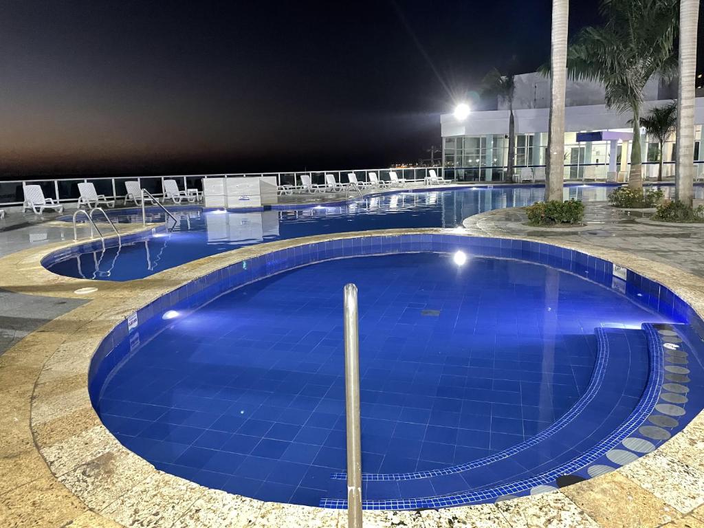 a large blue swimming pool at night at Apartamento en Cartagena Makrotours in Cartagena de Indias