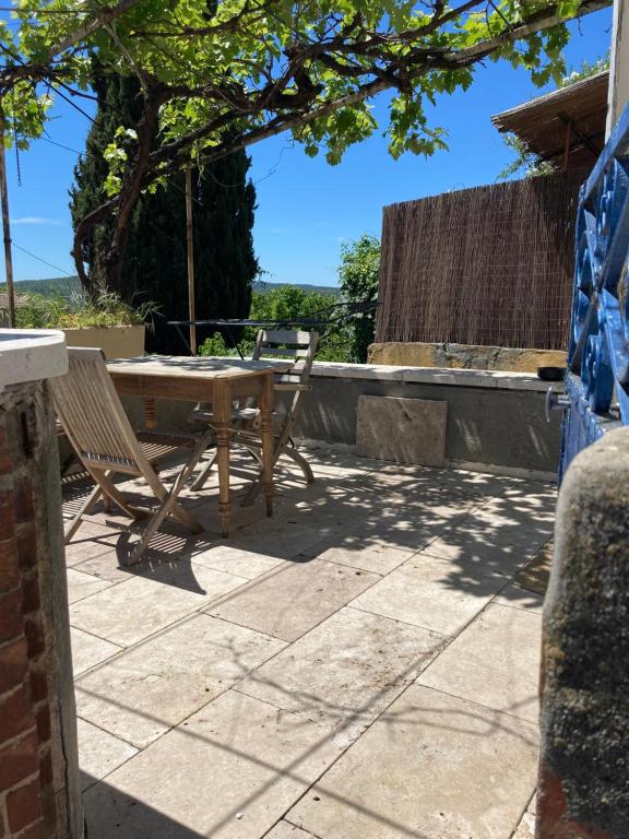 uma mesa e cadeiras no pátio de uma casa em Chez Enzo em Pierrevert