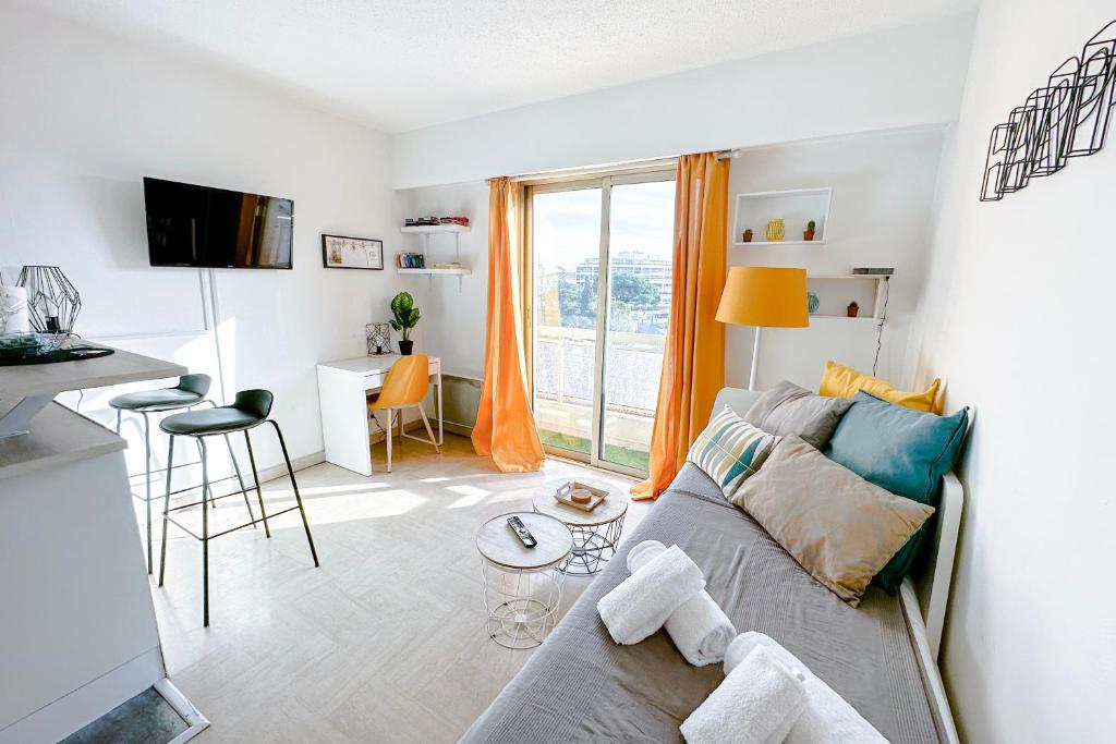 a living room with a couch and a table at GUIGNON - Apart sunny comfort close to the Port & Station in Antibes