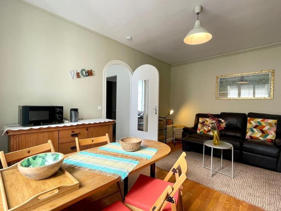 un salon avec une table et un canapé dans l'établissement Fontainebleau - Chez Marguerite, à Fontainebleau