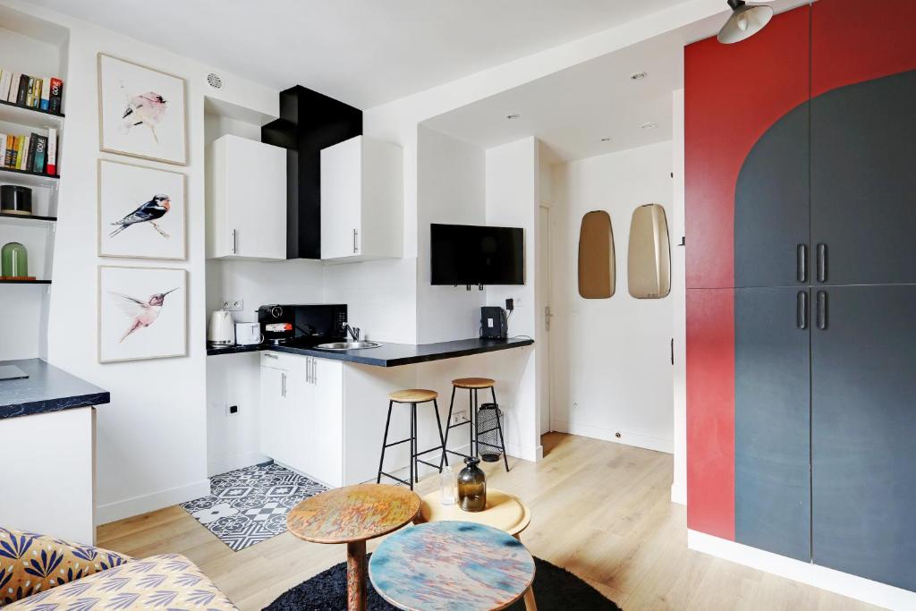 una cucina e un soggiorno con bancone e sgabello di Pick A Flat's Apartements in Louvre-Rivoli - Rue du Roule a Parigi