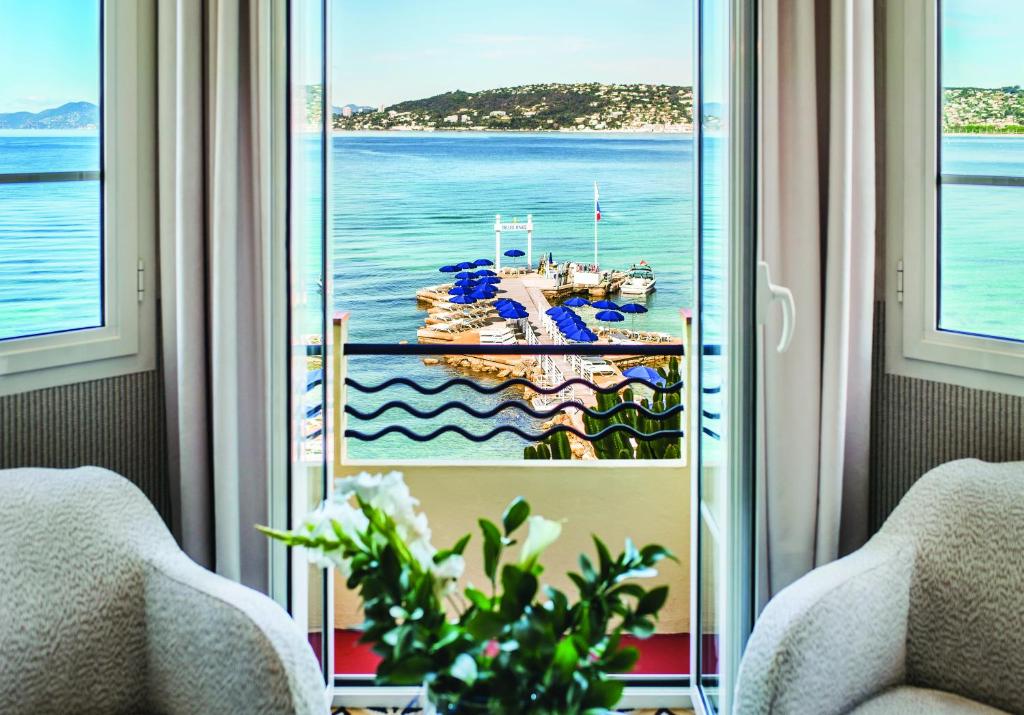 a room with a window with a view of the ocean at Hôtel Belles Rives in Juan-les-Pins