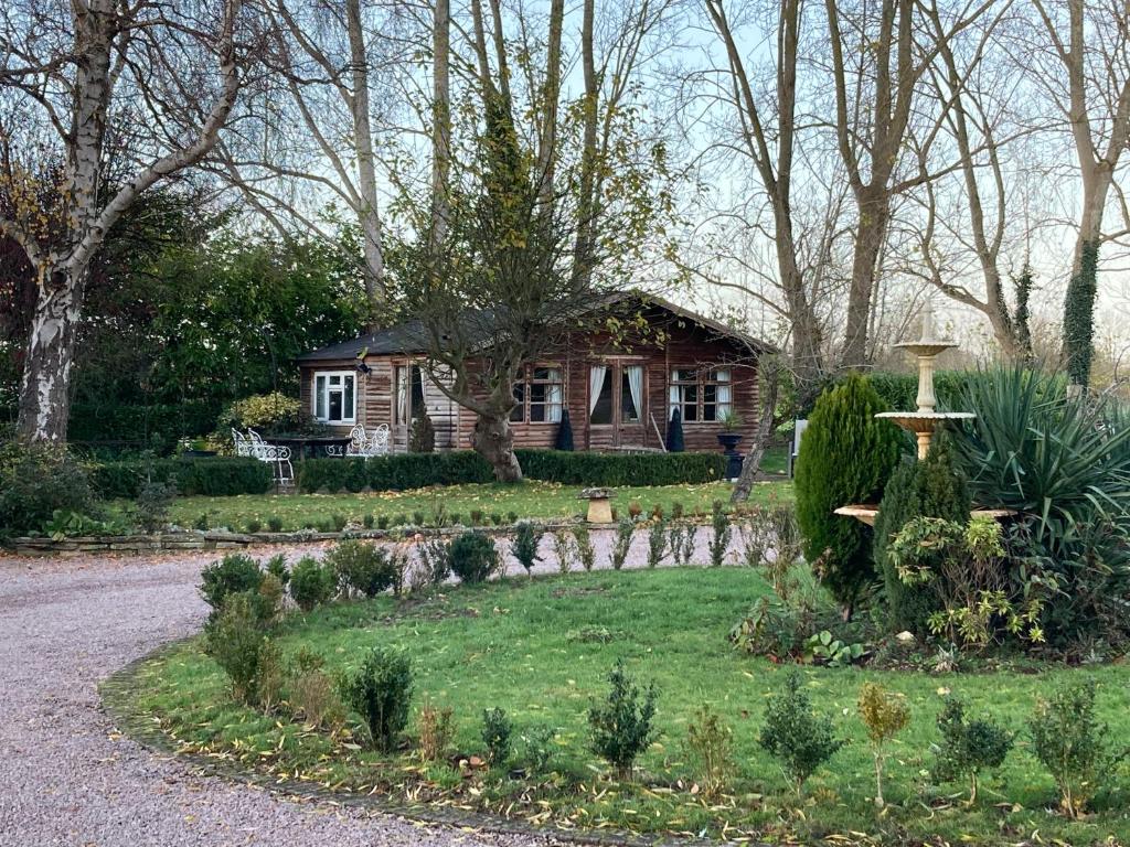 a house with a garden in front of it at Log Cabin, Conveniently Situated halfway between Stratford and Warwick in Stratford-upon-Avon