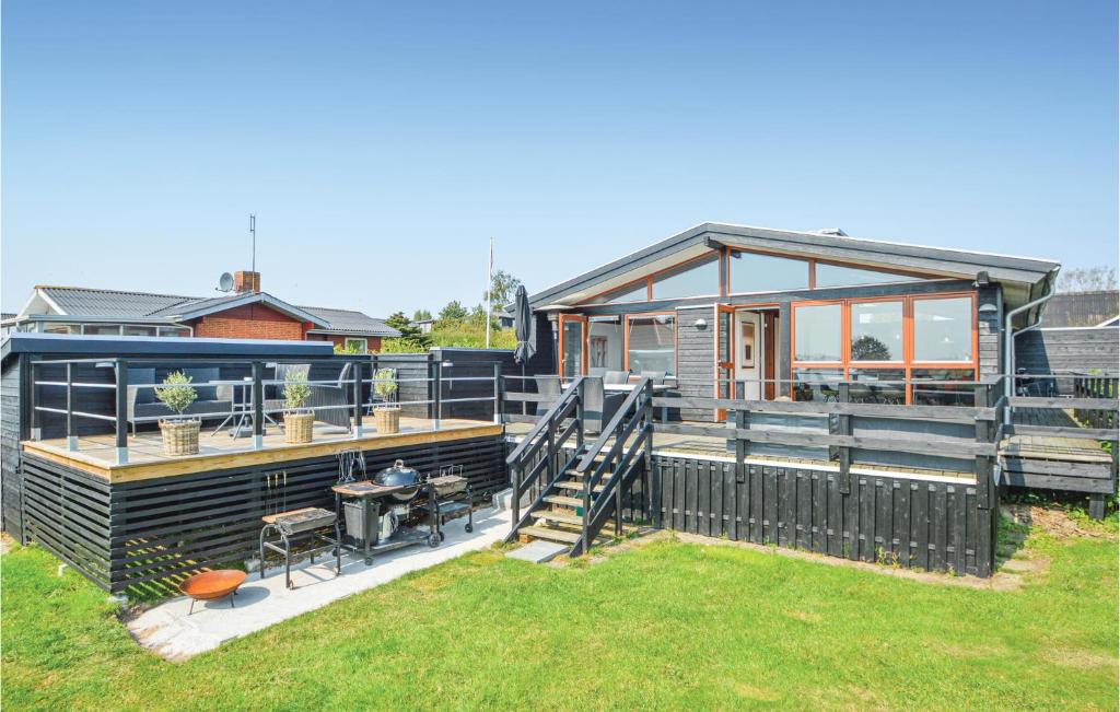 een huis met een groot terras met een grill bij Beautiful Home In Hejls With House Sea View in Hejls