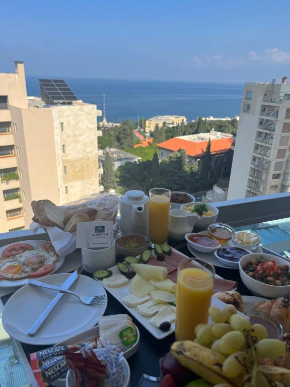 uma mesa com comida e bebidas numa varanda em El Sheikh Suites Hotel em Beirute