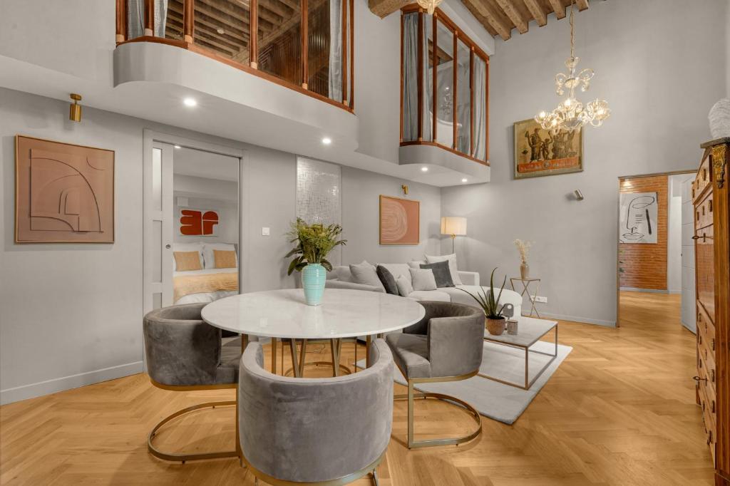 a living room with a table and a couch at Les Relais du Capitole - Appartements d'hôtes in Toulouse
