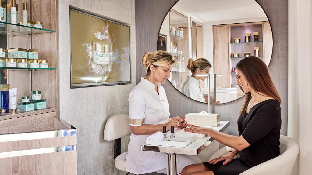 a woman in a beauty room with a mirror at Hôtel Belles Rives in Juan-les-Pins