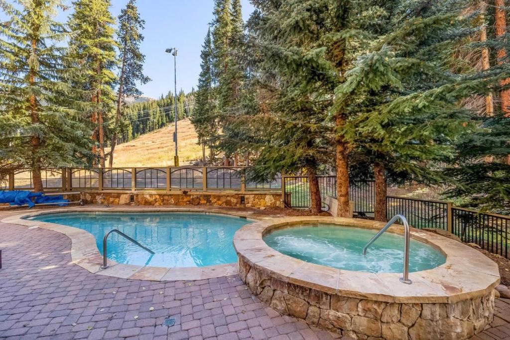 a swimming pool in a yard with trees at Lone Eagle Ski In Ski Out Condo in Dillon