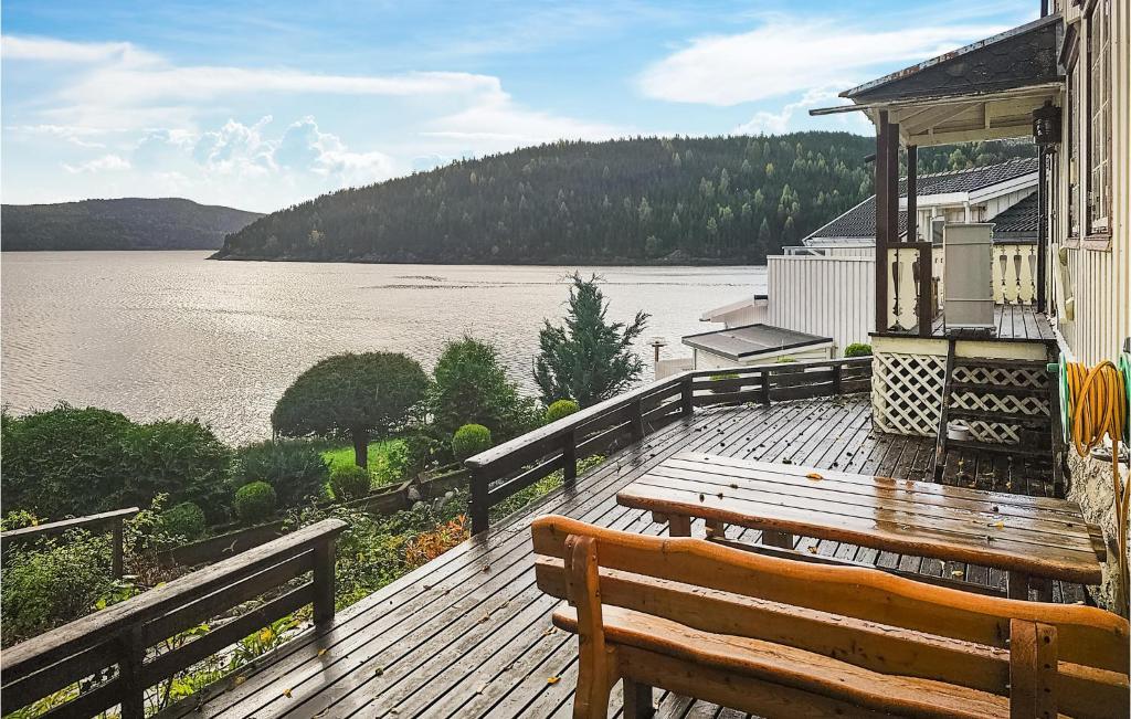 una terraza de madera con un banco y vistas al lago en Stunning Home In Mosvik With House Sea View, en Mosvik