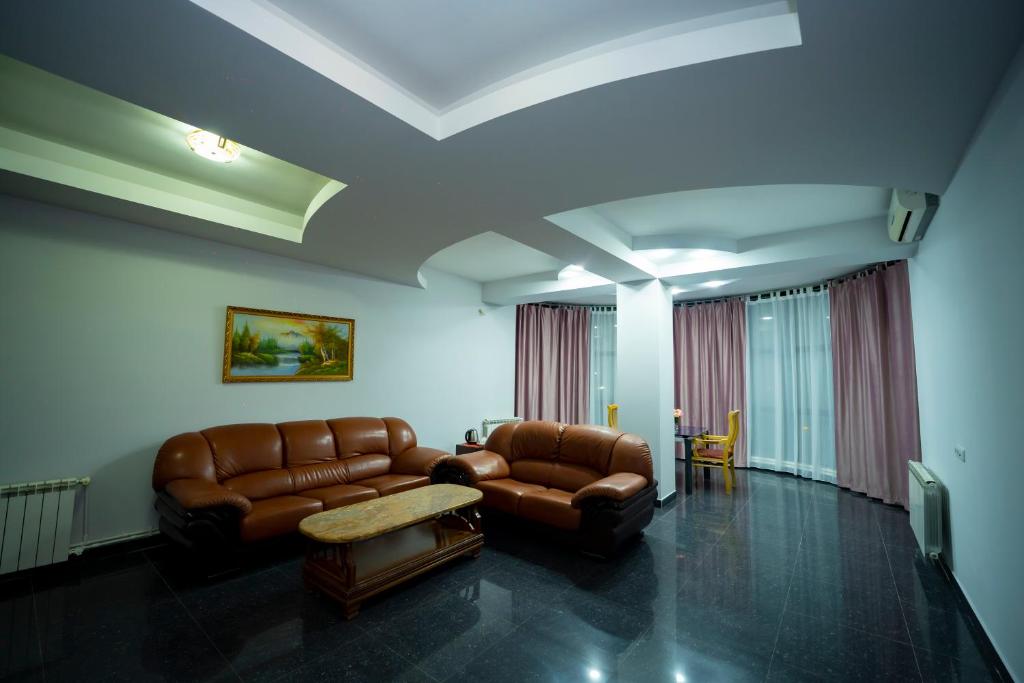 a living room with a leather couch and a table at Continental Hotel Complex in Yerevan