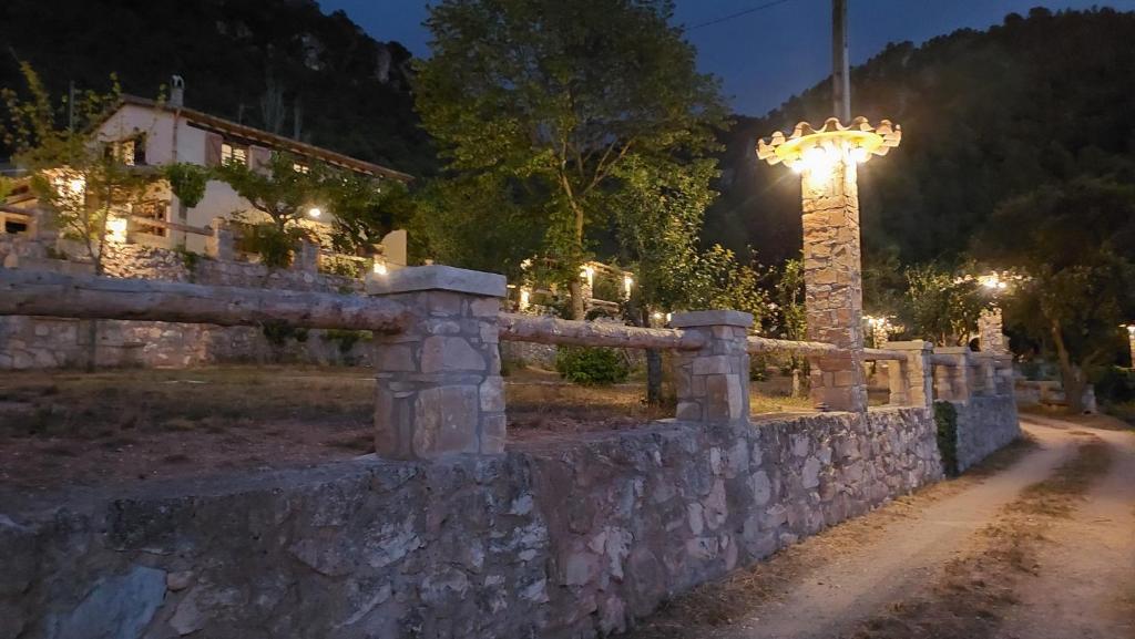 a stone wall with a street light in front of a house at La Calma Montblanc Prenafeta in Prenafeta