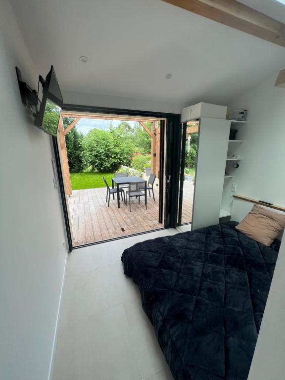 1 dormitorio con 1 cama y patio con mesa en Sun studio en Capbreton