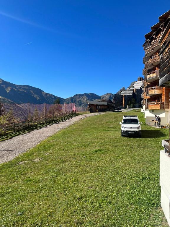 a car parked on the grass next to a building at TILIA - Quartier Falaise - 2 pièces in Avoriaz