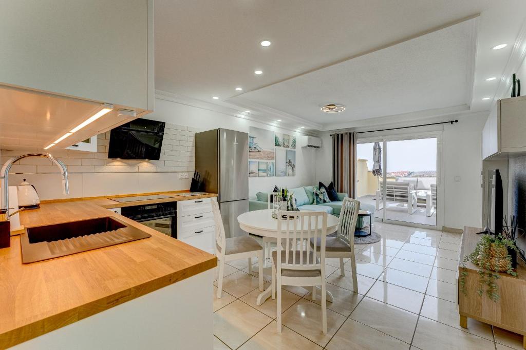 a kitchen with a table and a dining room at Ramada Costa Adeje Apartment in Adeje