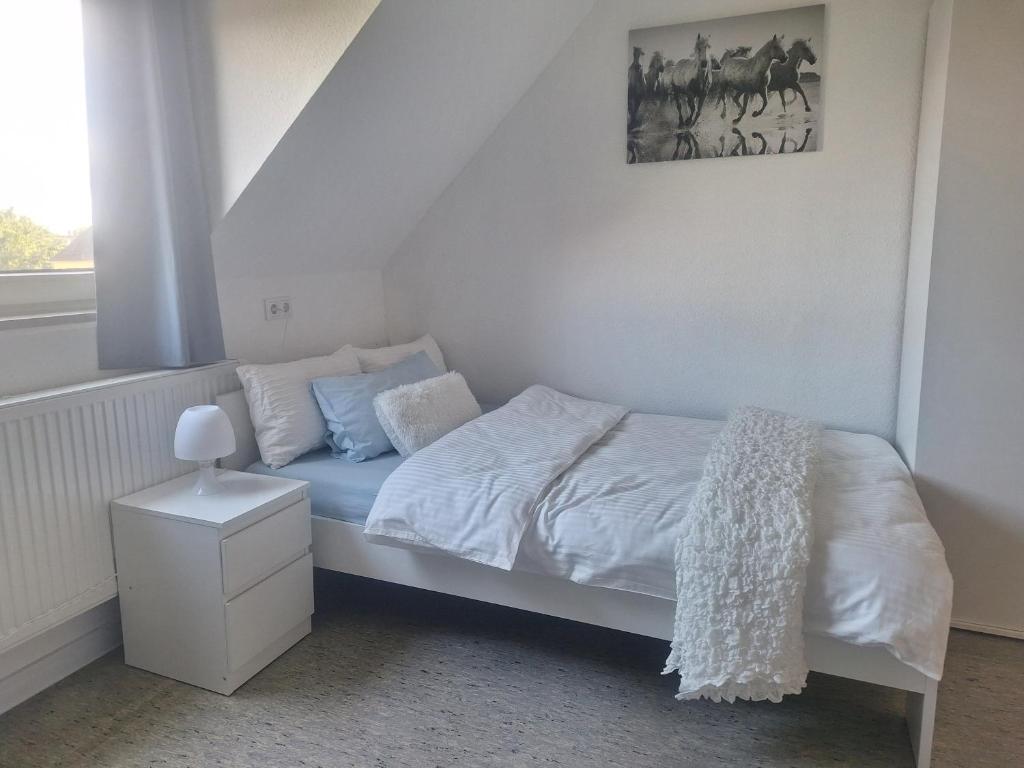 1 dormitorio blanco con 1 cama y una foto en la pared en Studio-Apartment 22 - 3R1 en Essen