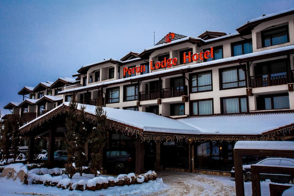 a hotel in the snow with a sign on it at Hotel Perun Lodge in Bansko