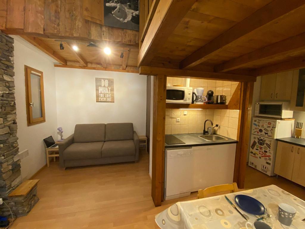 ein Wohnzimmer mit einem Sofa und einer Küche in der Unterkunft Studio La Plagne Montalbert , 1 pièce, 4 personnes - FR-1-181-2478 in Aime La Plagne