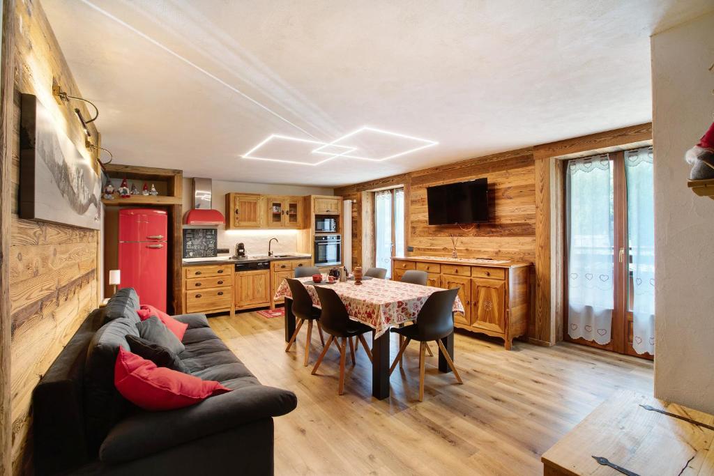 ein Wohnzimmer mit einem Sofa und einem Tisch in der Unterkunft Jorasses La Maison de Courma in Courmayeur
