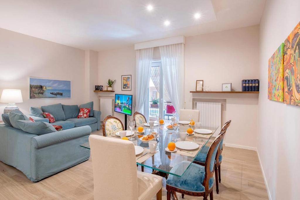 een woonkamer met een tafel en een blauwe bank bij Gemma di Zagara Apartment in Sorrento