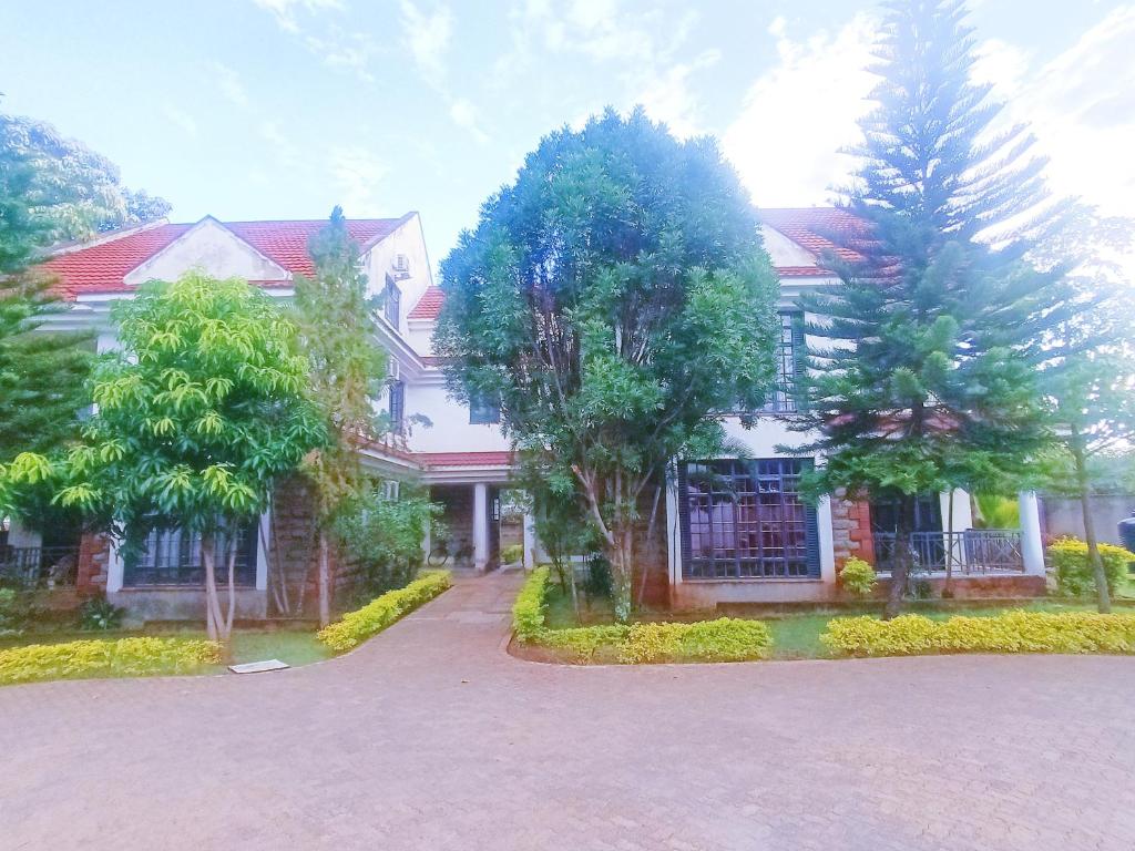 a large house with trees in front of it at Amigo apartments in Kisumu