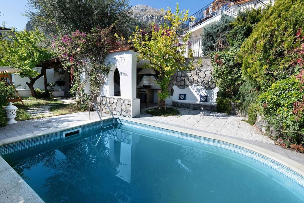 a swimming pool in front of a house at Villa Marinella close to the sea with private pool in Nerano