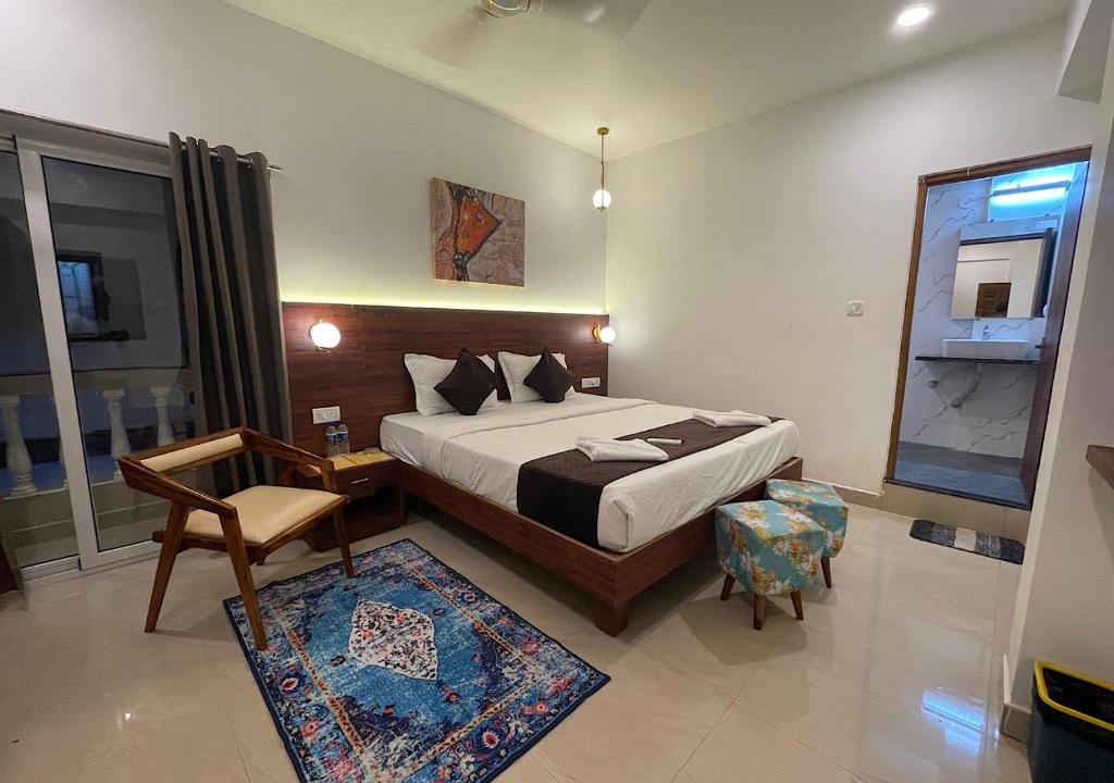 1 dormitorio con cama, silla y espejo en Baga Keys by RJ14, en Old Goa
