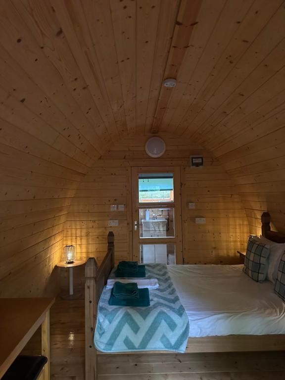 a bedroom with a bed in a wooden room at Fairburn Activity Centre in Contin